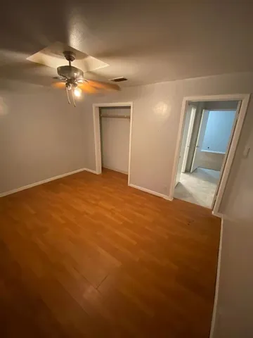 a view of empty room with window and ceiling fan