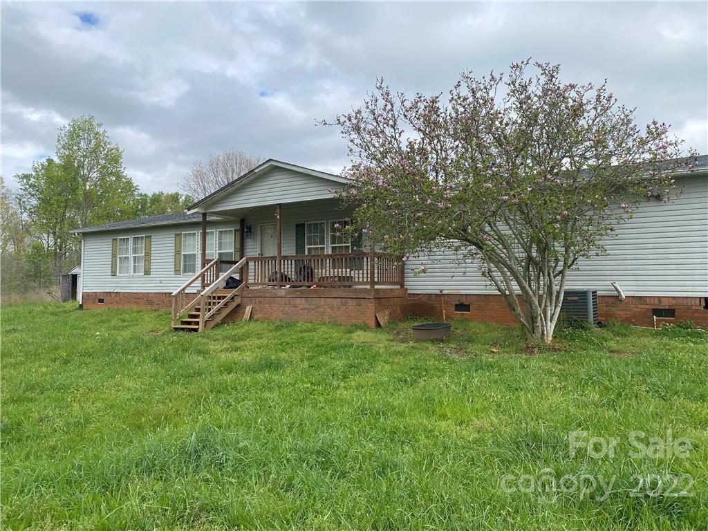 a view of a house with backyard and a tree