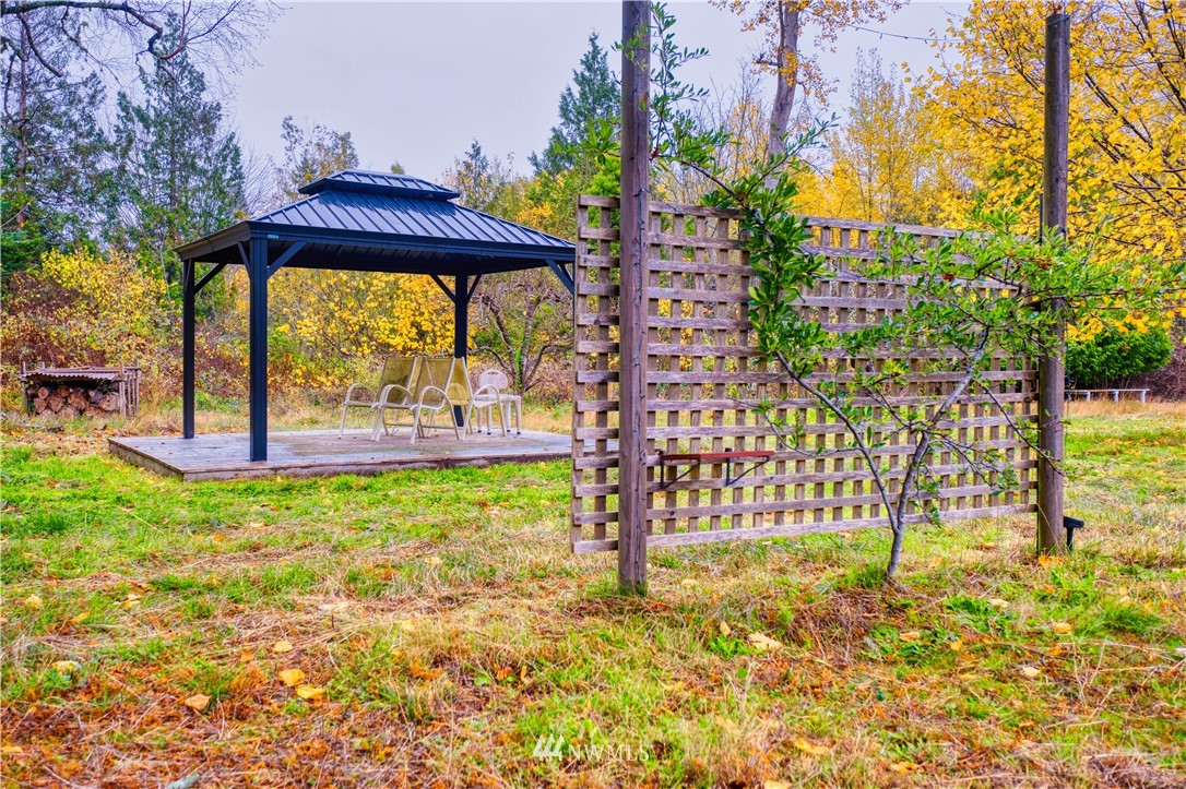 340 Boundary Bay Road Point Roberts, WA 98281 - Photo 5 of 17 a view of a garden with a bench under an umbrella