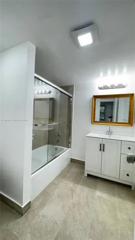 a view of an empty room with cabinet and mirrors