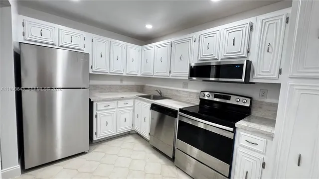 a kitchen with cabinets stainless steel appliances and white cabinets