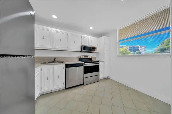 a kitchen with stainless steel appliances white cabinets and a refrigerator