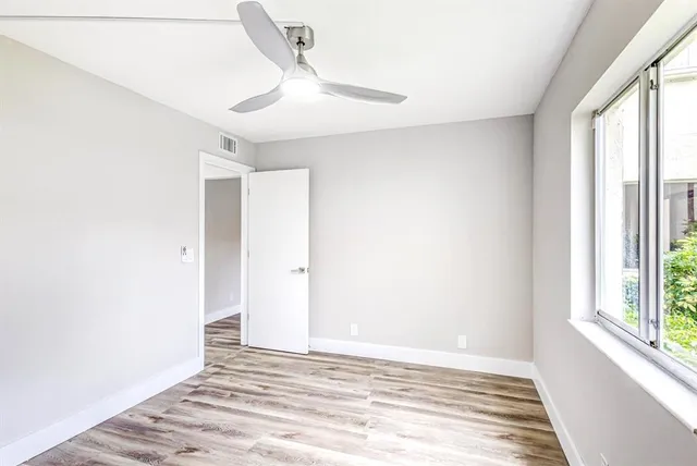 a view of a livingroom with wooden floor and window
