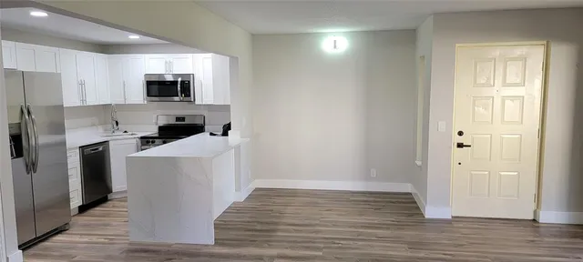 a room with stainless steel appliances a refrigerator a stove top oven a sink and dishwasher