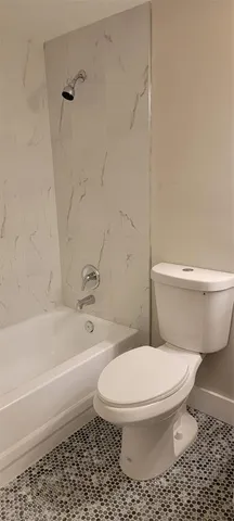 a white toilet and tub sitting next to a bathroom sink
