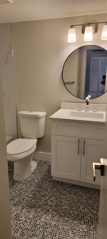 4829 Sable Pine Circle, Unit 1C West Palm Beach, FL 33417 - Photo 16 of 16 a bathroom with a toilet a sink and mirror