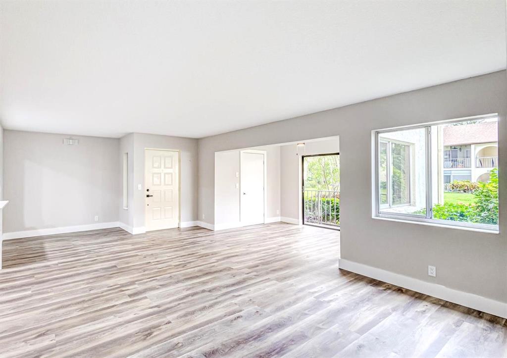 4829 Sable Pine Circle, Unit 1C West Palm Beach, FL 33417 - Photo 2 of 16 a view of an empty room with wooden floor and a window