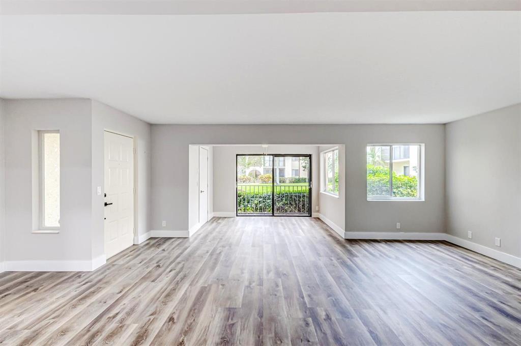 4829 Sable Pine Circle, Unit 1C West Palm Beach, FL 33417 - Photo 3 of 16 an empty room with wooden floor and windows