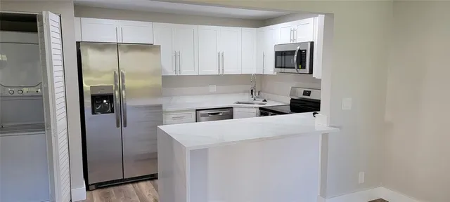 a kitchen with stainless steel appliances granite countertop a refrigerator and a microwave