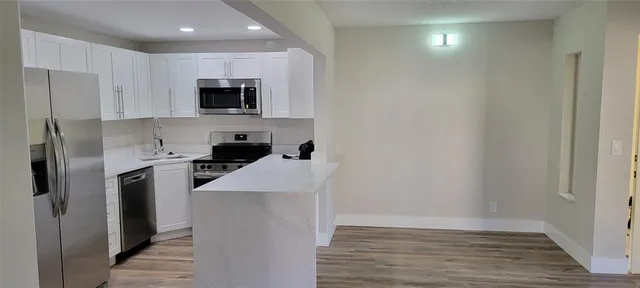 a kitchen with stainless steel appliances a refrigerator and a stove top oven