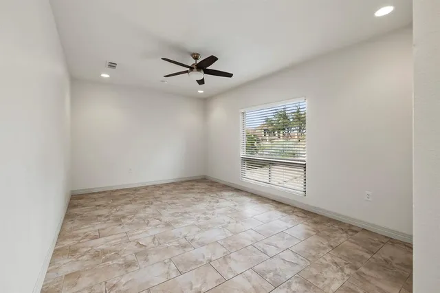 a view of empty room with ceiling fan