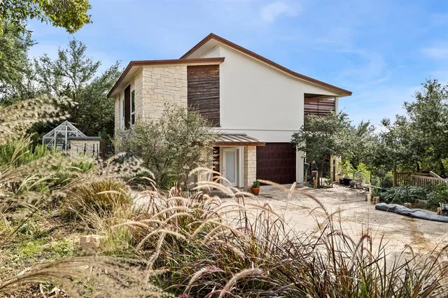 a front view of house with yard and trees in the background