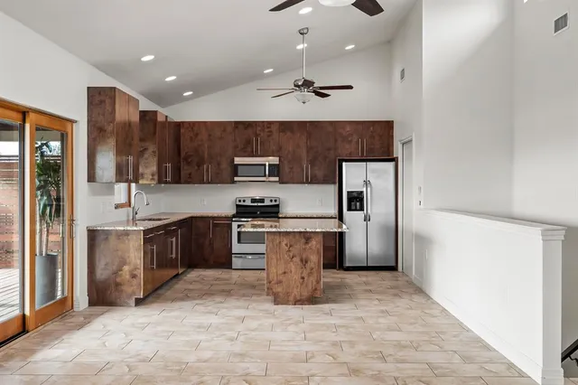 a large kitchen with a refrigerator and a stove top oven