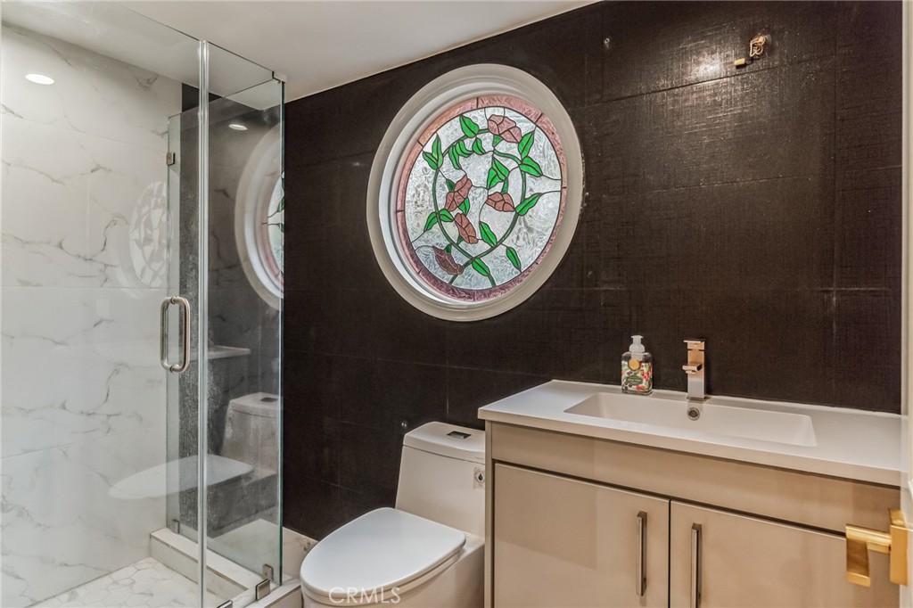 1432 Rutherford Drive Pasadena, CA 91103 - Photo 25 of 33 a bathroom with a toilet a sink and mirror