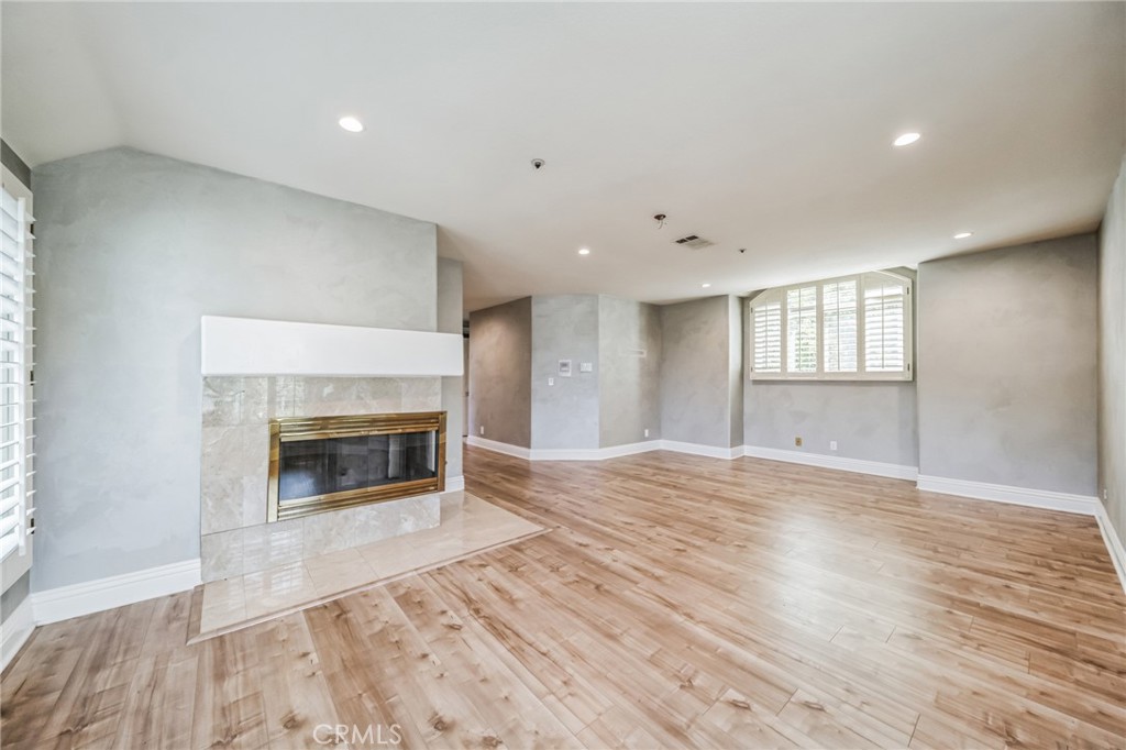1432 Rutherford Drive Pasadena, CA 91103 - Photo 27 of 33 an empty room with wooden floor fireplace and windows