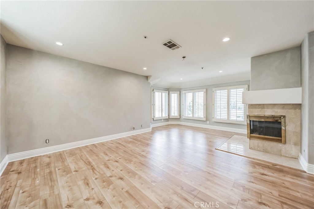 1432 Rutherford Drive Pasadena, CA 91103 - Photo 30 of 33 an empty room with wooden floor and a fireplace