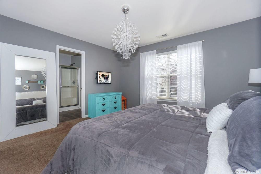 10029 Caldwell Depot Road Cornelius, NC 28031 - Photo 22 of 34 a bedroom with a bed chandelier and a window
