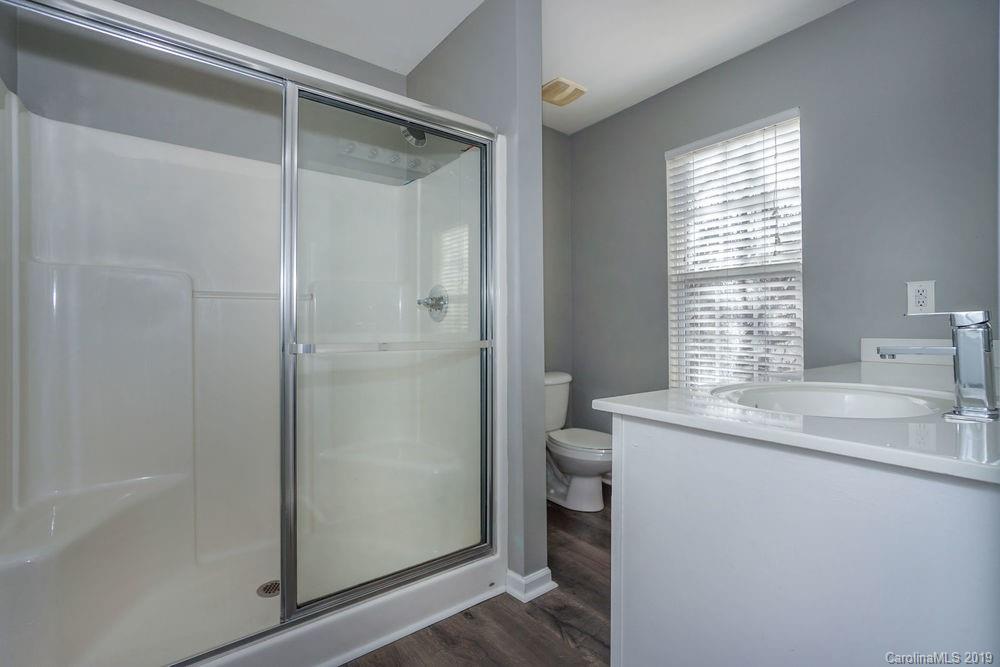 10029 Caldwell Depot Road Cornelius, NC 28031 - Photo 24 of 34 a bathroom with a granite countertop sink a toilet and shower