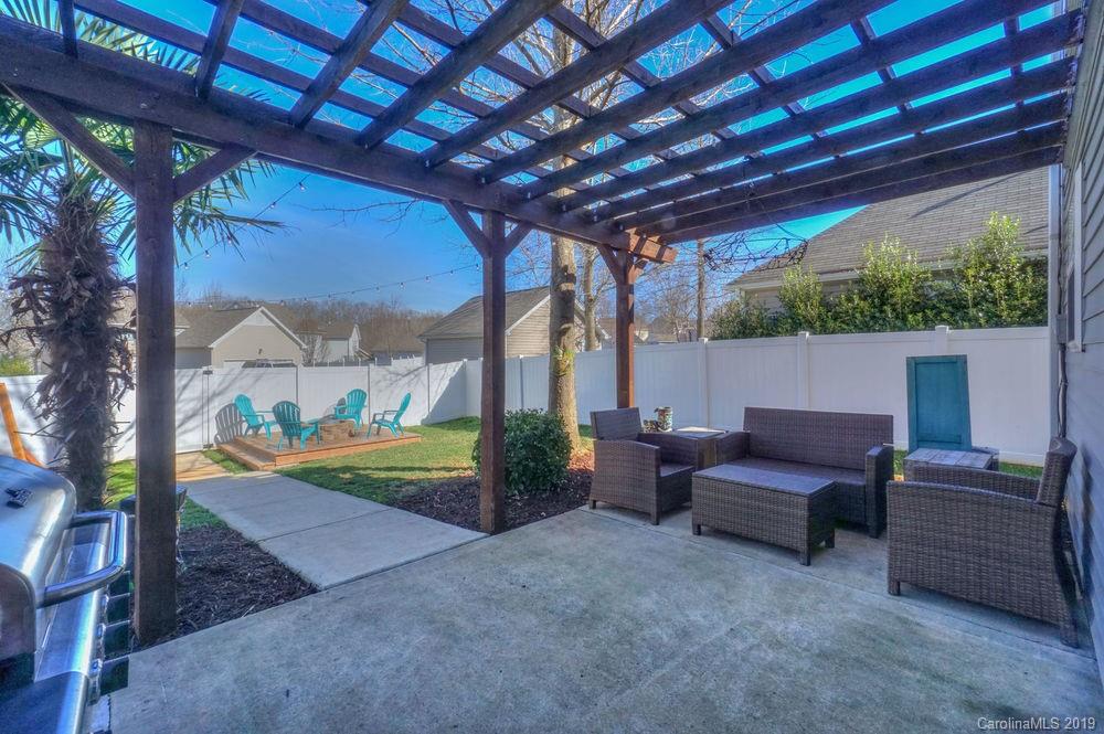 10029 Caldwell Depot Road Cornelius, NC 28031 - Photo 32 of 34 a view of patio with a table and chairs under an umbrella with a big yard
