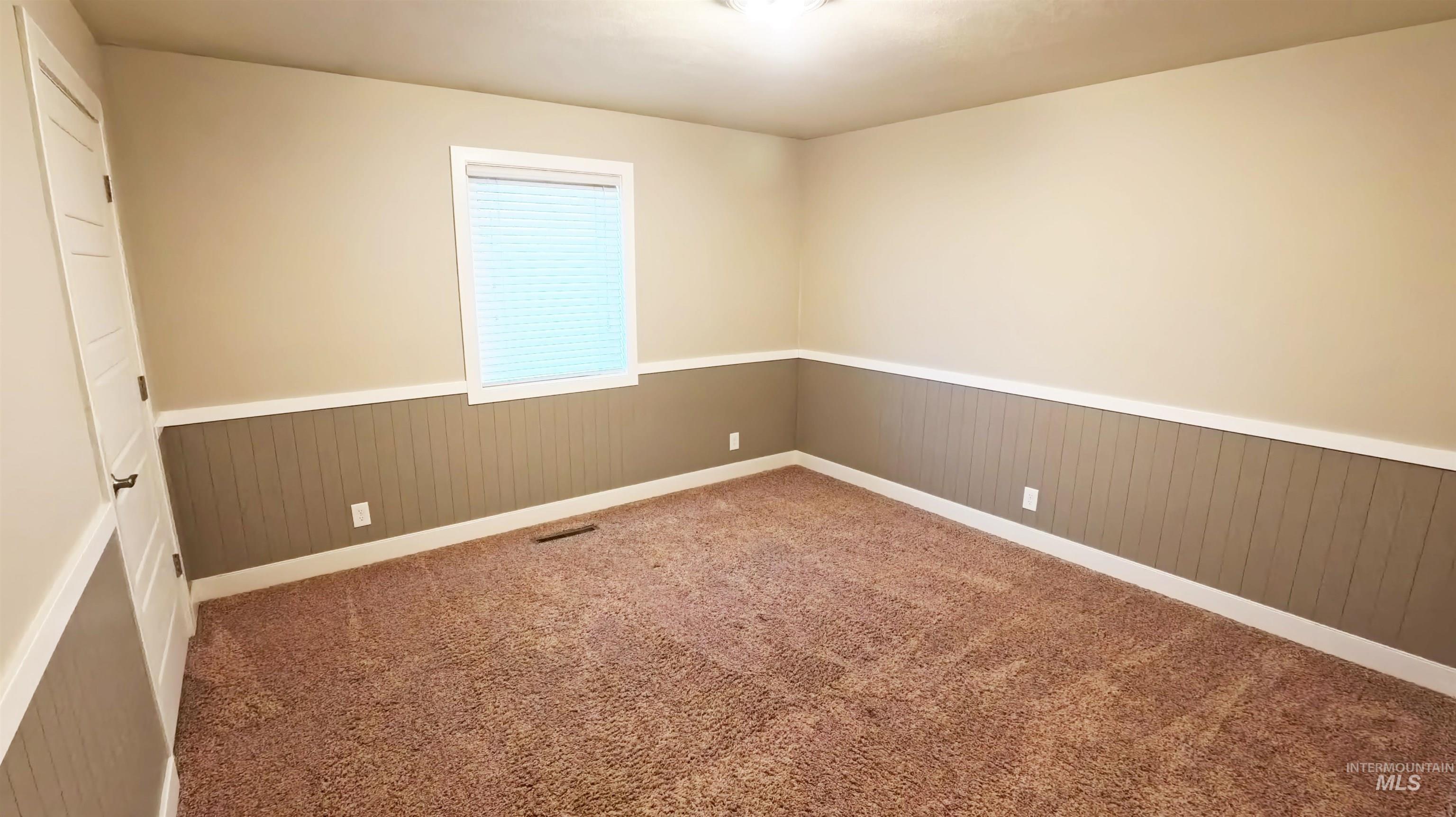 223 Hillcrest Road Burley, ID 83318 - Photo 14 of 27 Spare room with a wainscoted wall, carpet floors, and wood walls