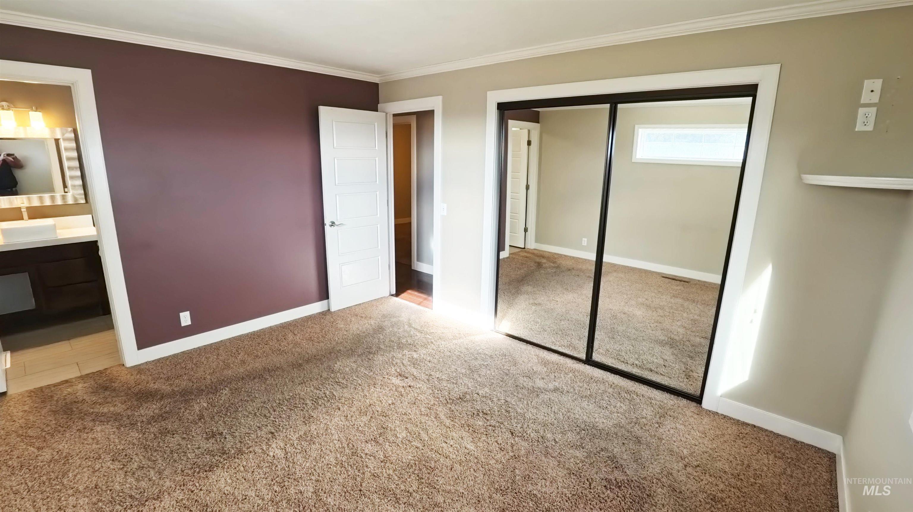 223 Hillcrest Road Burley, ID 83318 - Photo 15 of 27 Unfurnished bedroom featuring carpet flooring, a closet, ornamental molding, and ensuite bathroom