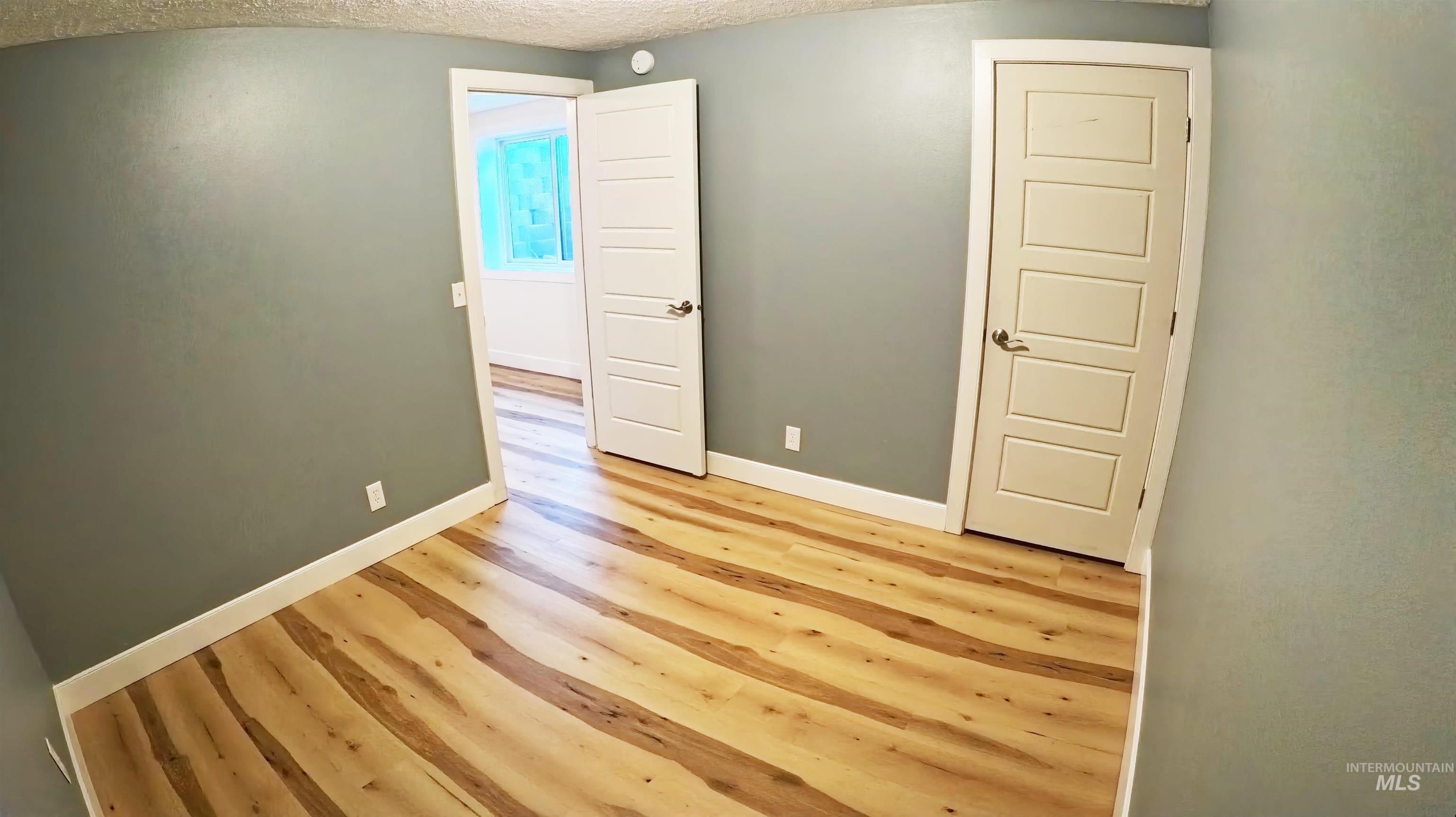 223 Hillcrest Road Burley, ID 83318 - Photo 16 of 27 Empty room featuring wood finished floors and a textured ceiling