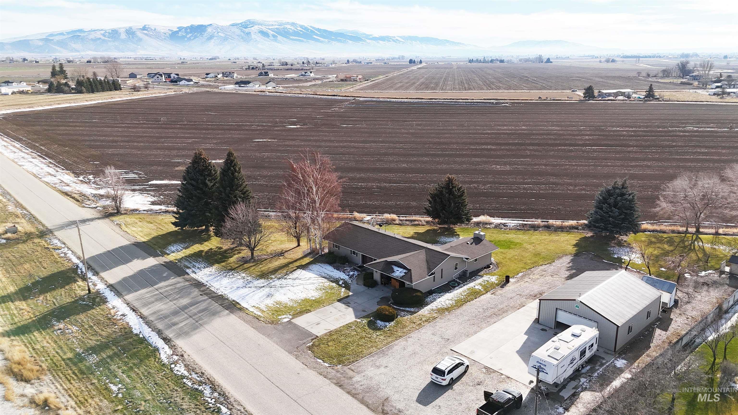 223 Hillcrest Road Burley, ID 83318 - Photo 3 of 27 Aerial view of sparsely populated area with rows of crops and mountains
