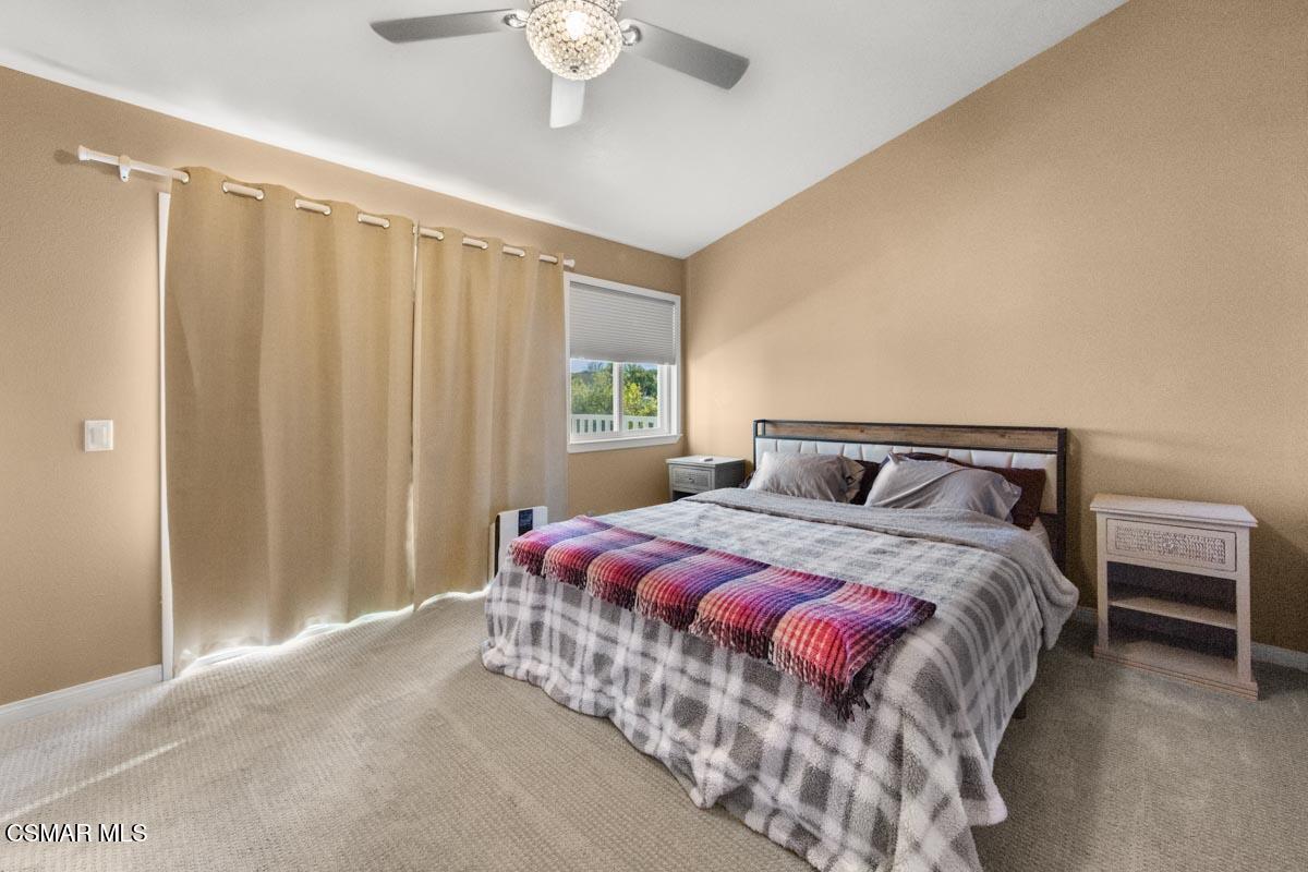 3918 Cochran Street, Unit 19 Simi Valley, CA 93063 - Photo 14 of 22 a bedroom with a bed and a chandelier