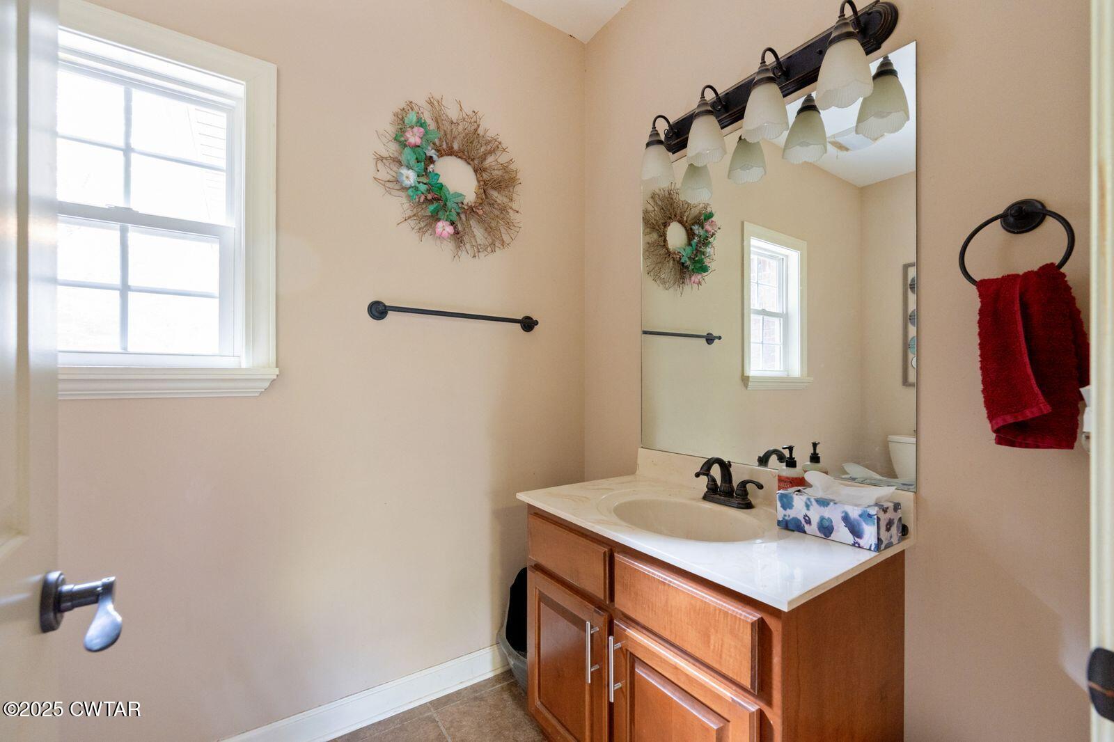 2400 Sand Ridge Bargerton Road Lexington, TN 38351 - Photo 19 of 48 a bathroom with a sink a mirror and a window