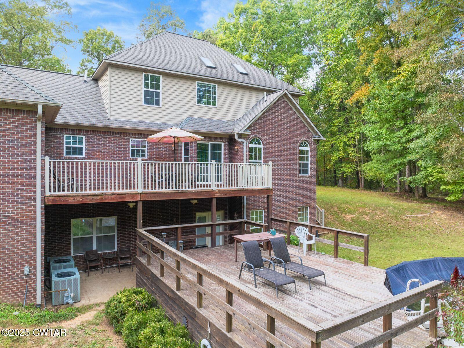 2400 Sand Ridge Bargerton Road Lexington, TN 38351 - Photo 3 of 48 a roof deck with table and chairs under an umbrella