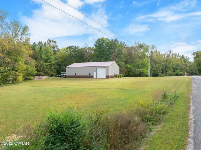 a view of a house with backyard and a parking space