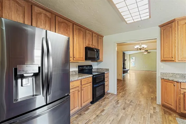 a kitchen with stainless steel appliances granite countertop a refrigerator stove and sink