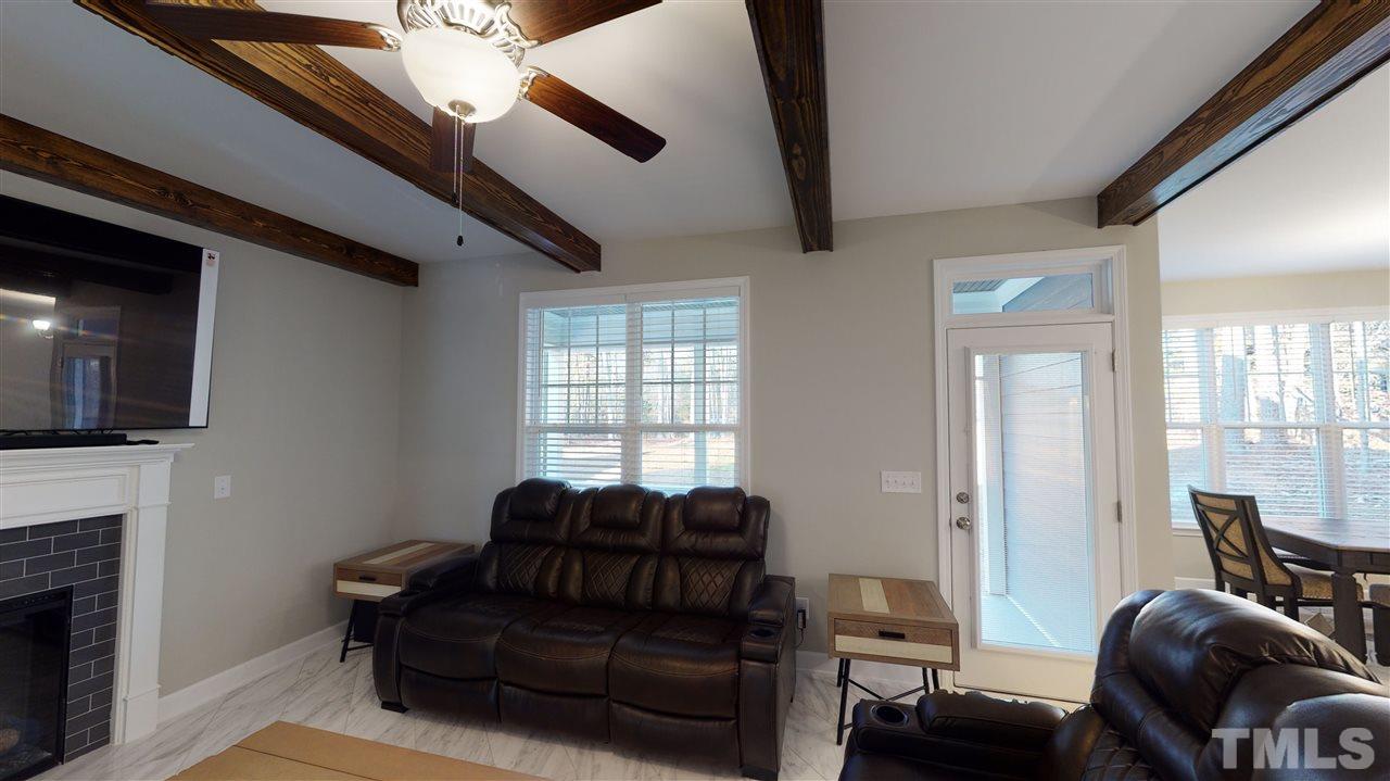 3430 Dutchman Road Raleigh, NC 27610 - Photo 15 of 21 a living room with furniture a flat screen tv and a fireplace
