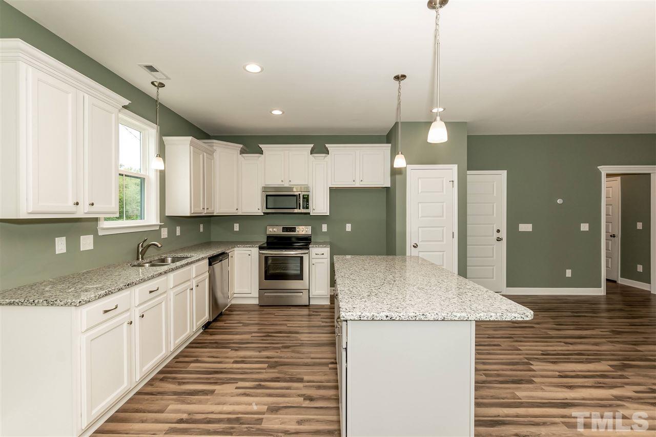 3430 Dutchman Road Raleigh, NC 27610 - Photo 17 of 21 a kitchen with stainless steel appliances granite countertop a sink a stove and a refrigerator