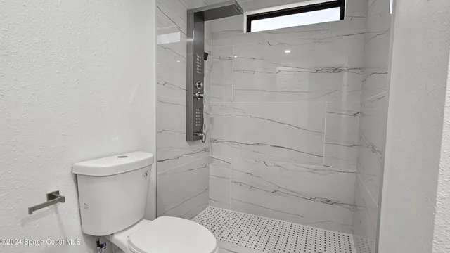 a bathroom with a toilet and a shower