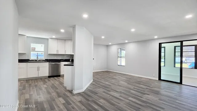 a view of kitchen with a sink wooden cabinet and a refrigerator