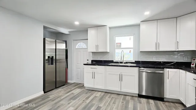 a kitchen with stainless steel appliances granite countertop a stove a sink and a refrigerator