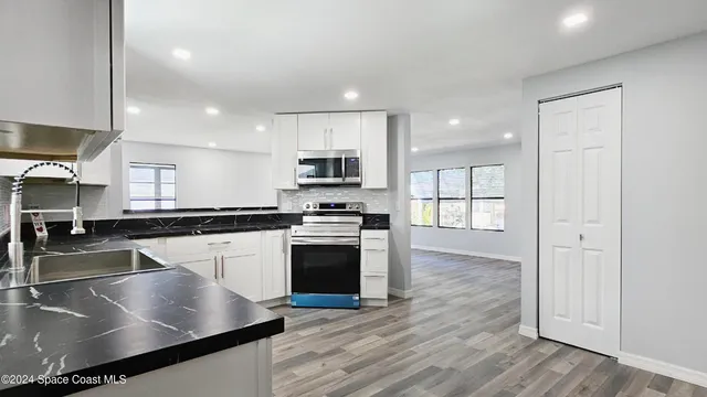 a kitchen with stainless steel appliances granite countertop a stove a sink and a refrigerator