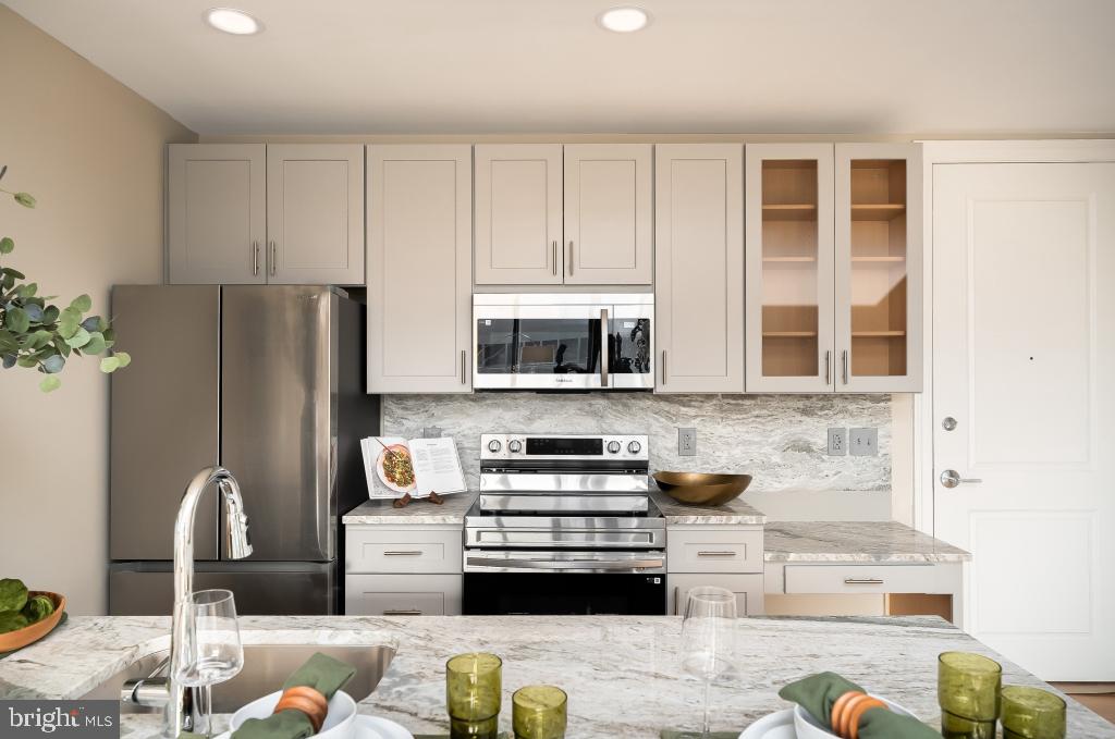 2301-61 John F Kennedy Boulevard, Unit 306 Philadelphia, PA 19103 - Photo 5 of 39 a kitchen with stainless steel appliances granite countertop a refrigerator and a stove top oven