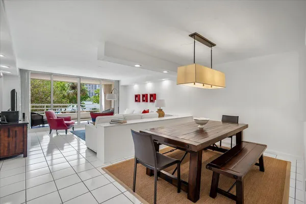 a view of a dining room and livingroom with furniture wooden floor a rug a flat screen tv