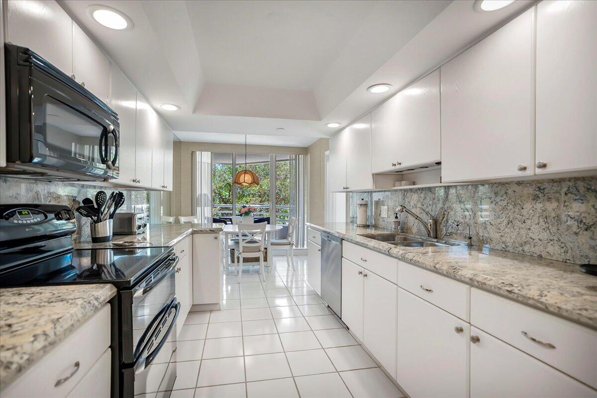 4201 North Ocean Boulevard, Unit 203 Boca Raton, FL 33431 - Photo 21 of 54 a kitchen with a sink stove and cabinets