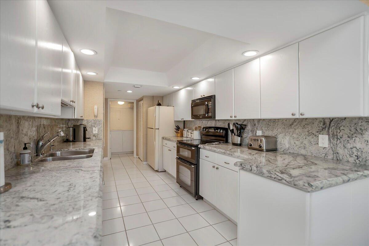4201 North Ocean Boulevard, Unit 203 Boca Raton, FL 33431 - Photo 22 of 54 a kitchen with a sink a counter top space cabinets and stainless steel appliances