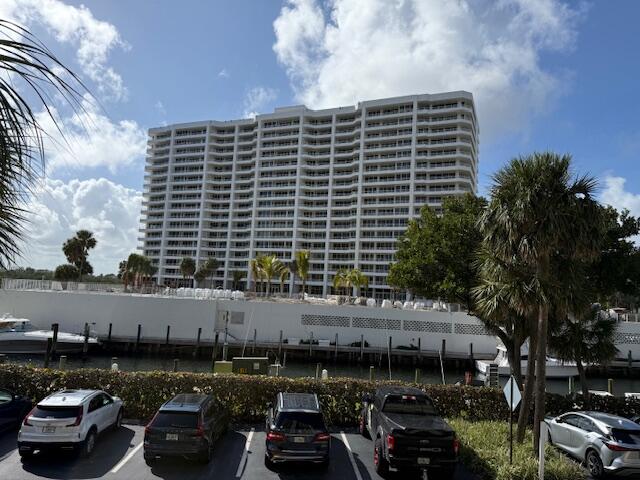 4201 North Ocean Boulevard, Unit 203 Boca Raton, FL 33431 - Photo 49 of 54 a front view of a building with lots of cars and trees