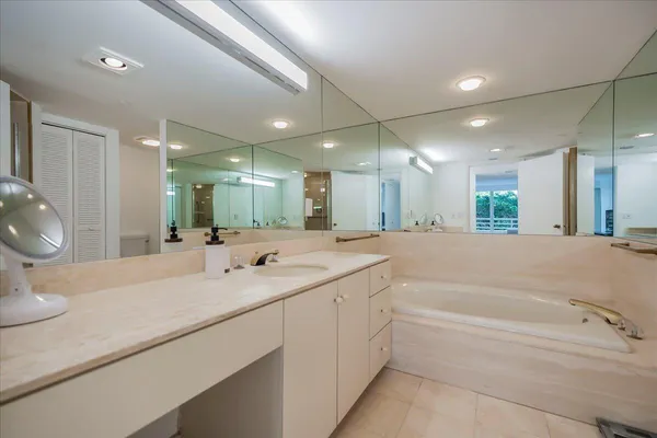 a bathroom with a tub a sink and a mirror
