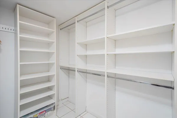 a view of walk in closet with empty racks