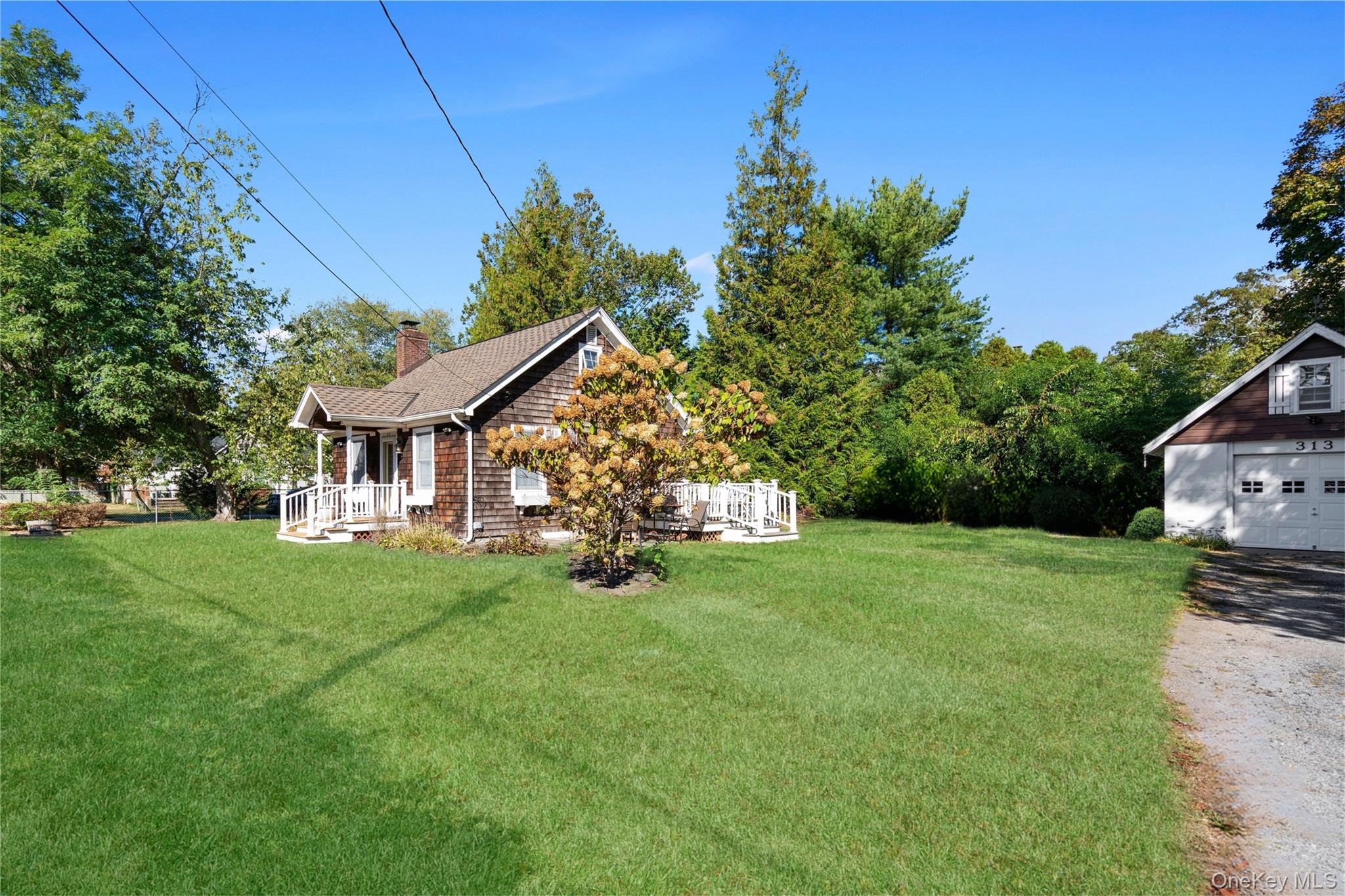 313 Forest Road West Mastic Beach, NY 11951 - Photo 3 of 19 a view of a house with a big yard plants and large trees