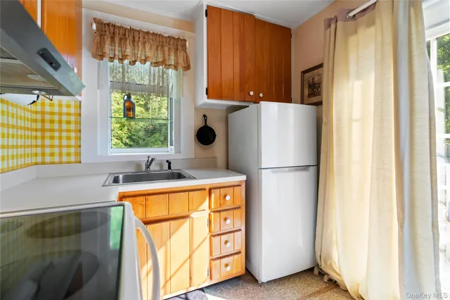 a kitchen with a refrigerator a stove and a window