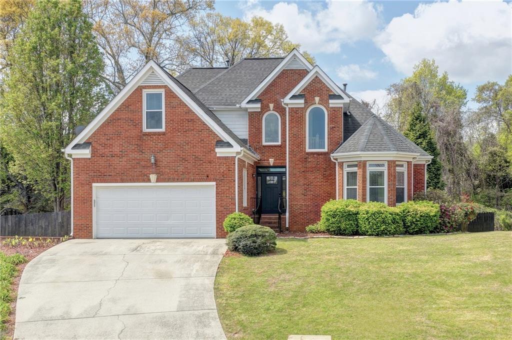 1005 Lewis Ridge Circle Lawrenceville, GA 30045 - Photo 1 of 74 a front view of a house with a yard and garage