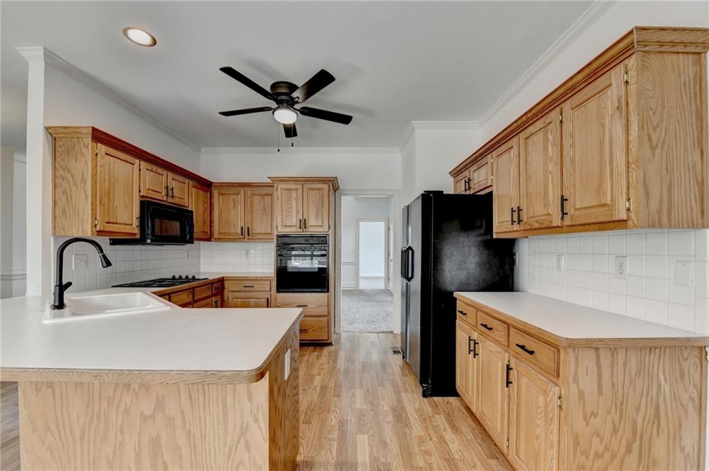 1005 Lewis Ridge Circle Lawrenceville, GA 30045 - Photo 18 of 74 a kitchen with stainless steel appliances granite countertop a refrigerator a stove top oven a sink dishwasher and white cabinets with wooden floor