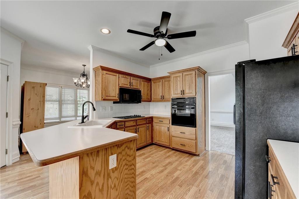 1005 Lewis Ridge Circle Lawrenceville, GA 30045 - Photo 19 of 74 a kitchen with stainless steel appliances a sink a stove a refrigerator a microwave oven with white cabinets and wooden floor